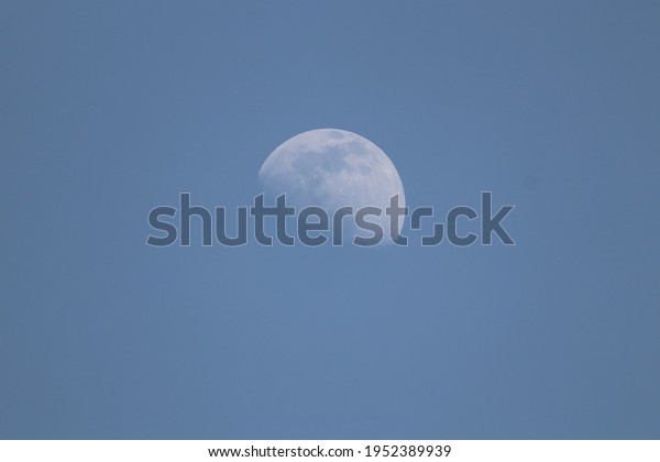 Half Moon in blue sky The Moon is an\
astronomical body that orbits planet Earth, being Earth\'s only\
permanent natural\
satellite