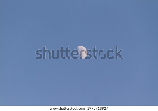Half of moon in blue sky\
close view 