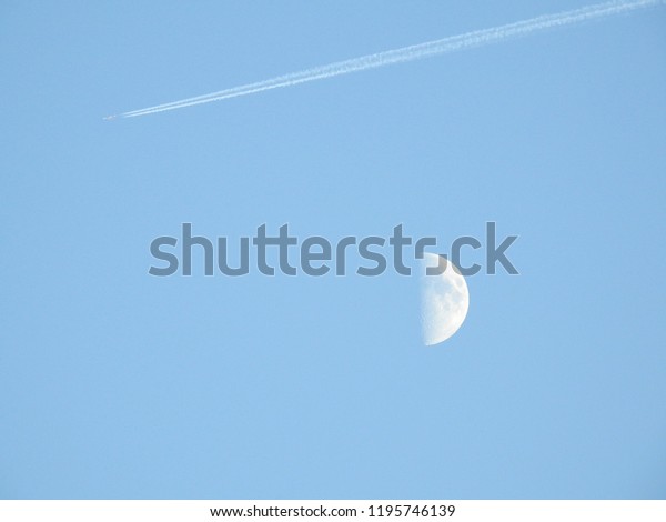 Half moon in bluesky and\
airplane