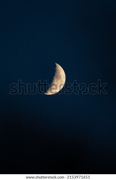 half moon in a clean dark\
blue sky