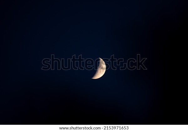 half moon in a clean dark\
blue sky