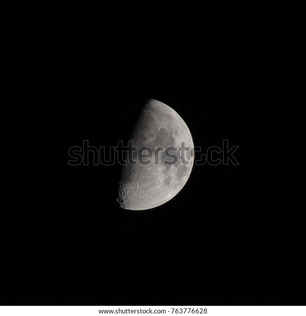 Half Moon with craters as seen through a\
photographic 180mm objective, concept of astronomy and telescope\
amateur backyard night sky\
observation