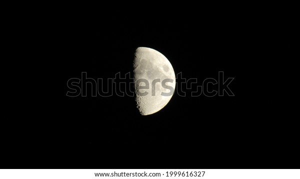 half moon in the night sky. clear night sky with\
bright moon.