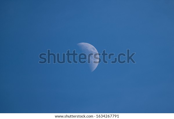 half moon photographed\
during the day.Due to changes in the operating cycle, sometimes the\
surface crater of the moon can be seen under the blue sky during\
the day.