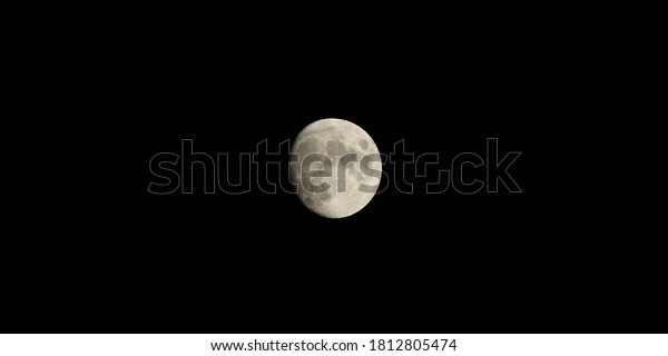 a half moon shining in
black night