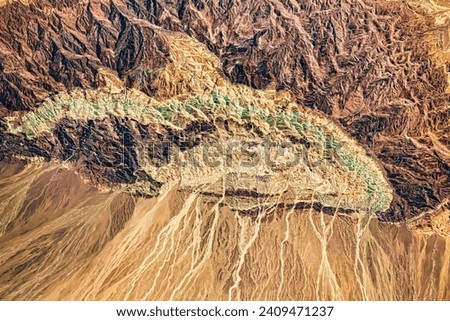 Half Mountain. The desert mountain in Iran is a geologic menagerie of fault lines, exposed volcanic rocks, and alluvial fans. Elements of this image furnished by NASA.