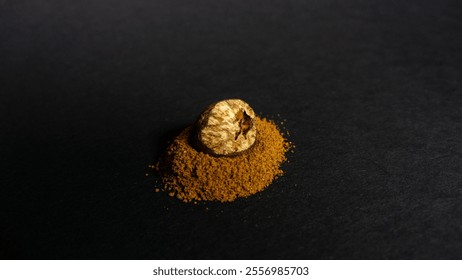 Half a nutmeg rests on a pile of grated nutmeg against a black background. - Powered by Shutterstock