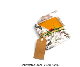 A Half Open Christmas Present Or Gift With Christmas Wrapping Paper, Twine, Ribbon, Present Topper And A Blank Gift Tag. Copyspace, Isolated On White Background. Opening Christmas Gift Concept.