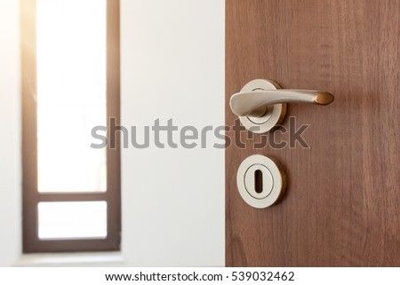 Half opened door to a empty room. Door handle, door lock. Welcome, to new home concept
