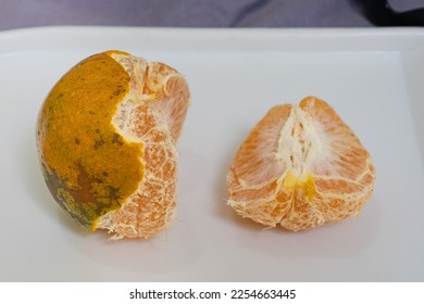 half oranges with peel and half peeled on a white cutting board as background - Shutterstock ID 2254663445