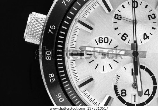 a half of a part of the men\'s watch of\
chronographs closeup in black white\
tone