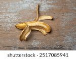 half peeled over ripe banana with creamy flesh exposed on table top surface, almost rotten or spoiled, unappealing fruit taken from above with copy space