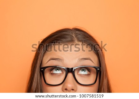 half portrait of a young girl with glasses looking up