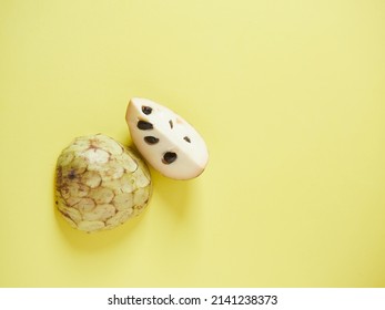 half and quarter custard apple, chirimoya, on a yellow background