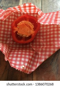 Half A Red Pepper In A Waxed Reusable Food Wrap On Wooden Board