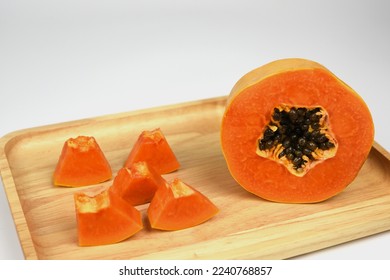 half of ripe papaya fruit with seeds on wooden board . - Shutterstock ID 2240768857