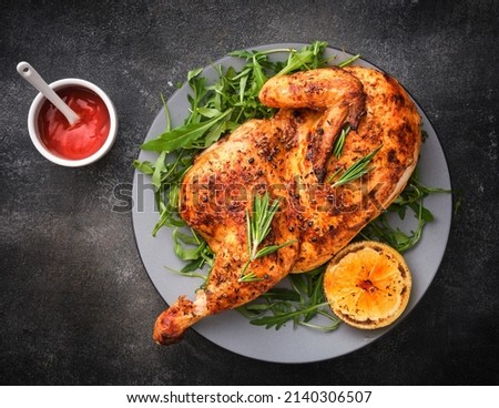 Half roasted chicken Piri Piri served with lemon and sauce . Grilled poultry.