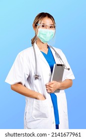 Half Shot Photo Of Female Doctor In Uniform With Mask And Face Shield Holding On Digital Tablet In Hands.