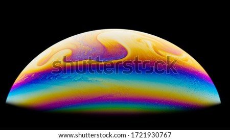 Half a soap bubble. Close-up. Black background. Bright colors. Side view. A high resolution. Imitation of an unknown planet. Children's entertainment. Science fiction.