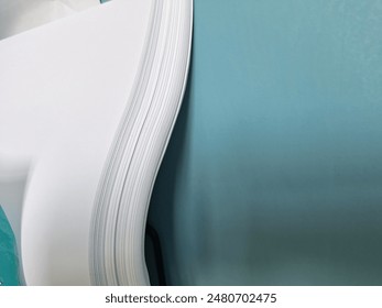 Half Stack of HVS Empty White Paper 70 gsm isolated on blue wall background. For high quality printing. Office Supplies and Stationeries