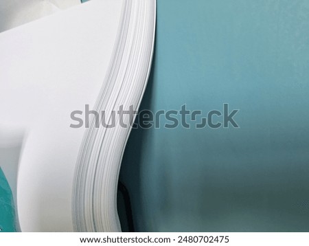 Half Stack of HVS Empty White Paper 70 gsm isolated on blue wall background. For high quality printing. Office Supplies and Stationeries