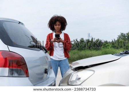 Half Thai African driver check for damage after a car accident before taking pictures and sending insurance. Online car accident insurance claim after submitting photos and evidence to an insurance.
