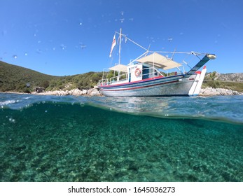 Half Underwater Photo Of A Boat In A Beautiful Beach Of Samos Island