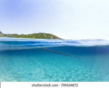 Half Underwater Photo Of The Ships Chain. With Island.