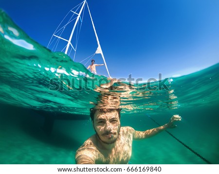 Similar – Foto Bild Glücklicher Mann, der Tauchkleidung und -ausrüstung trägt und lächelt, während er am Strand aus dem Wasser steigt.