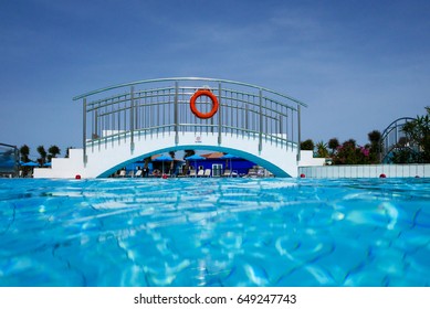 Half Underwater Shot, Clear Turquoise Water On Swimming Pool And Foothbridge.