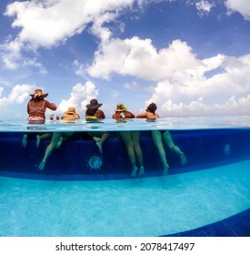 Half Underwater Split Image Of Young Women Having Fun In Hotel Pool In Caribbean Sea. Concept Of Vacation And Bachelorette Pool Party