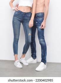 Half Young Man And Woman In Torn Jeans With Shoes In Studio Background