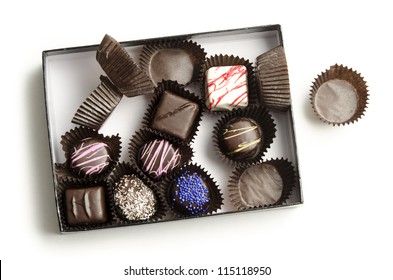 Half-Eaten Box Of Chocolate Truffles With Wrappers