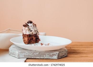 Half-eaten piece of cake on a plate, leftover chocolate cake with cherries