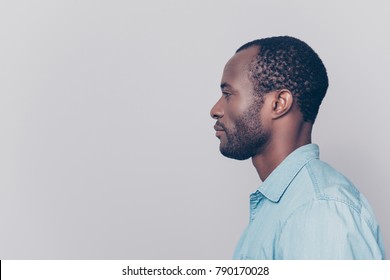 Half-faced Side Profile View Portrait Of Thoughtful Pensive Serious Confident Handsome Guy Dressed In Light Blue Shirt, Isolated On Grey Background