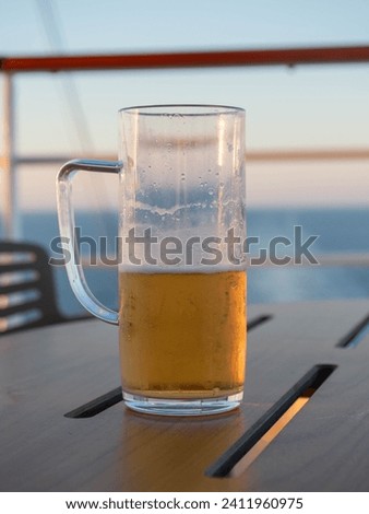 Half-full beer mug on a table in the sunshine
