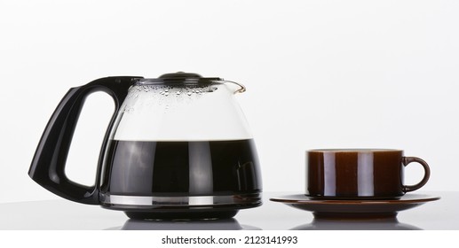 Half-Full Coffee Pot and brown cup over white
