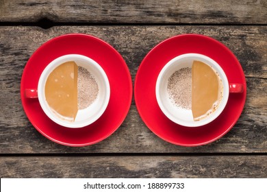 Half-full And Half Empty Cups Of Coffee On Wood Background