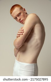 Half-legth Portrait Of Handsome Young Man Posing In White Underwear Isolated Over Grey Studio Background. Men's Fashion. Muscular Skinny Model. Concept Of Youth, Self-care, Body And Skin Care