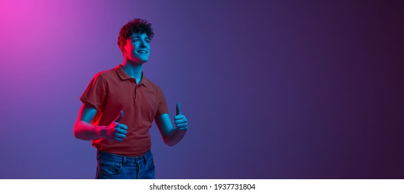 Half  length man's portrait in casual clothes isolated over gradient pink  purple background in neon light  Concept human emotion  facial expression  feelings  youth culture  Copy space for ad  Flyer