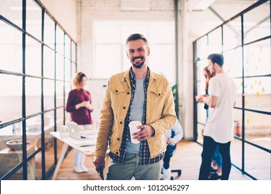 Half-length portrait of cheerful matured manager dressed in casual outfit having work break in office, successful coach of designers team satisfied with career and productive job with colleagues