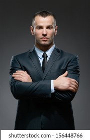 Half-length Portrait Of Man Wearing Business Suit And Black Tie With Crossed Arms