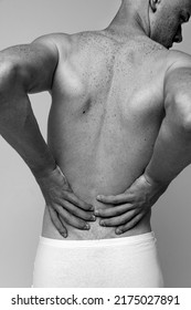 Half-length Portrait Of Muscular Male Back Isolated Over Grey Studio Background. Model Posing In Underwear. Black And White Image. Concept Of Men's Health, Beauty, Body And Skin Care, Fitness