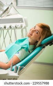 Half-length Portrait Of Nice Smiling Blonde Sitting In The Dentist Chair Looking At Us