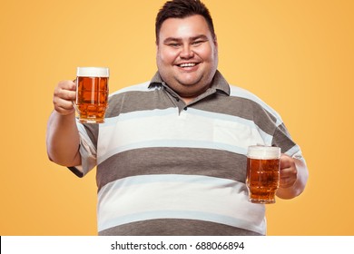 Half-length portrait of young fat man with holding the beer mug Isolated on solid background