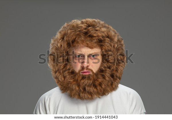 Half-length portrait of young very hairy man\
isolated over grey\
background.