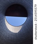 Half-moon of blue sky seen inside of a tall silo