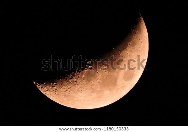 The half-moon on the black sky. The Moon is Earth\'s\
only natural satellite. At about one-quarter the diameter of Earth,\
it is the largest natural satellite in the Solar System relative to\
the size of 