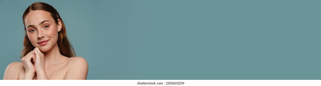 Half-naked Ginger Woman Smiling And Looking At Camera Isolated Over Blue Background