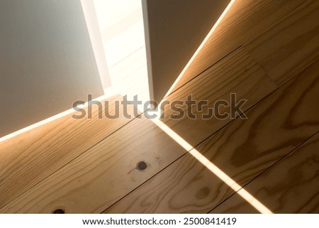 a half-open door lets in a beam of light onto the wood